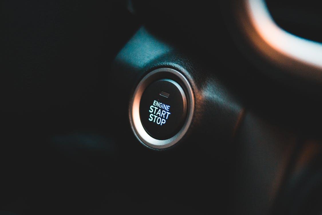 Convenient round button on black elegant dashboard of interior in contemporary comfortable automobile